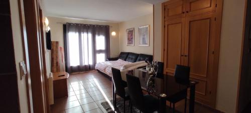 a living room with a table and chairs and a living room at Apartamentos Boabdil in Sierra Nevada