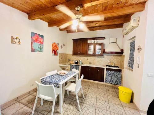 - une cuisine avec une table et des chaises dans la chambre dans l'établissement Pietre Nere House, à Pozzallo