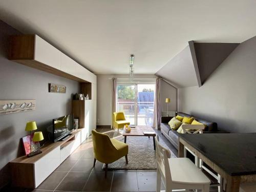 a living room with yellow chairs and a couch at Superbe appartement terrasse, proche de la plage in Bénodet