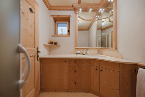 a bathroom with a sink and a mirror at Residence Nagler - BelaVal Apartments in Badia