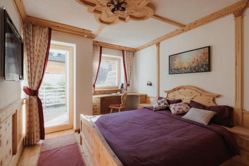 a bedroom with a large bed and a window at Residence Nagler - BelaVal Apartments in Badia