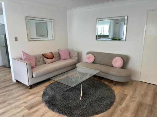 Ocean Front Apartment في كرونولا: غرفة معيشة مع أريكة وطاولة قهوة