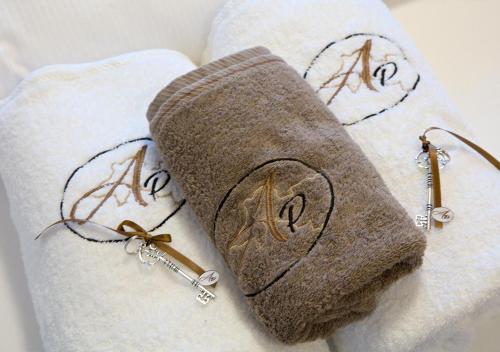 a towel with the letters a and a pair of earrings at Auberge Passepartout in Zeihen