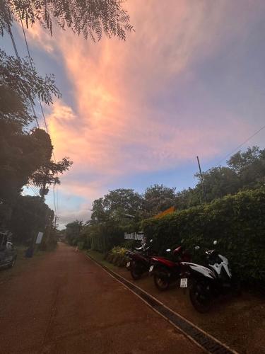 a couple of motorcycles parked on the side of a road at Hanoii House in Ko Mak