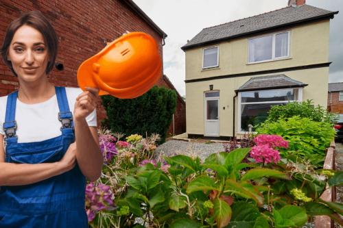 une femme tenant un chapeau orange dans un jardin dans l'établissement Maintenance, Transport, Medical Teams Bargain, 3 Bed Detached House, Mold, Sleeps 1 to 5, à Mold