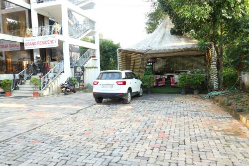 a small white car parked in front of a building at Airport Cochin Grand Residency , NEDUMBASSERY in Angamaly
