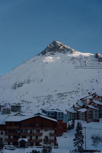 a snow covered mountain with a town in front of it at Appartement Pixel by ExplorHome in Tignes