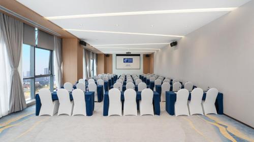 a conference room with chairs in front of a screen at Holiday Inn Express Chengdu Pidu by IHG in Chengdu
