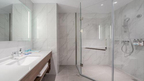 a white bathroom with a shower and a sink at Holiday Inn Express Chengdu Pidu by IHG in Chengdu