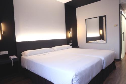a large white bed in a room with a mirror at Hotel Alfonso IX in Sarria