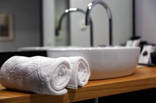 umywalka w łazience z dwoma ręcznikami na ladzie w obiekcie Hotel Alfonso IX w mieście Sarria