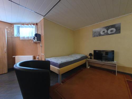 een kleine kamer met een bed en een televisie bij Ferienwohnung in der Siedlung in Klinga