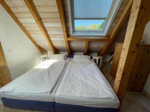 Cette chambre en bois comprend un grand lit et une fenêtre. dans l'établissement Glattbacher Hof Ferienwohnung 10, à Glattbach