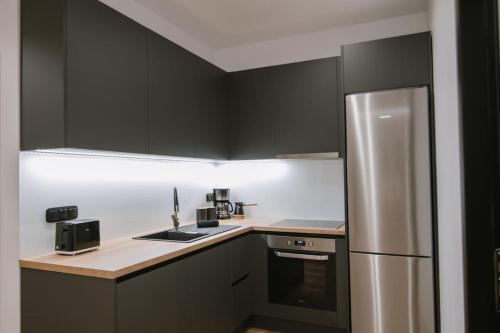 a kitchen with black cabinets and a stainless steel refrigerator at Elegant Residence in Heraklio Town