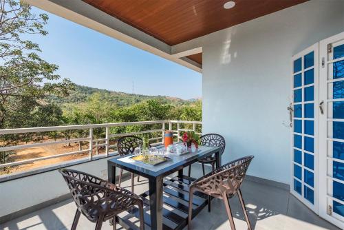 a dining room with a table and chairs on a balcony at Cosmicstays Ekantam - Serene Solitude With Inspiring Views at Velhe in Jadhavwadi