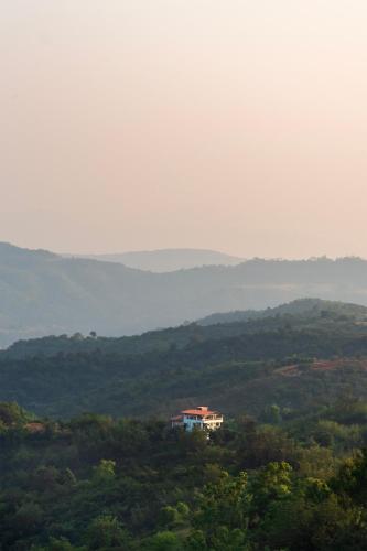 a house on top of a hill with trees at Cosmicstays Ekantam - Serene Solitude With Inspiring Views at Velhe in Jadhavwadi