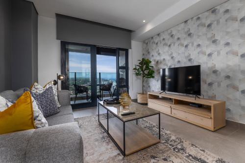 a living room with a tv and a couch at 2202 Oceans Apartment - by Stay in Umhlanga in Durban