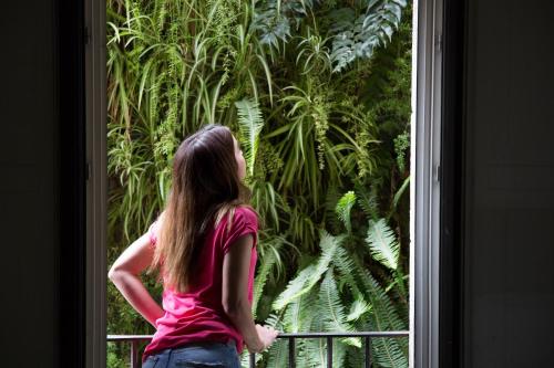 a woman standing in front of a window looking out at Eco Boutique Hostal Grau in Barcelona