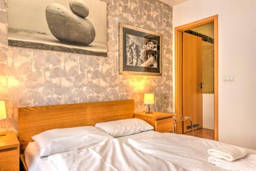 1 dormitorio con 1 cama y una pintura en la pared en Central Apartments, en Budapest