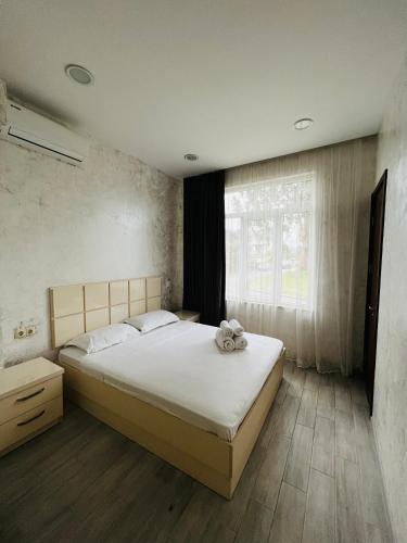 a bedroom with a large bed and a window at Apartments NITA in Batumi