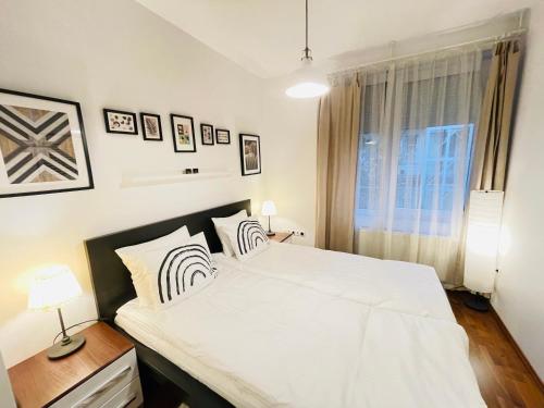 a bedroom with a large white bed and a window at Peony Székely Mihály Apartment - Free Garage in Budapest