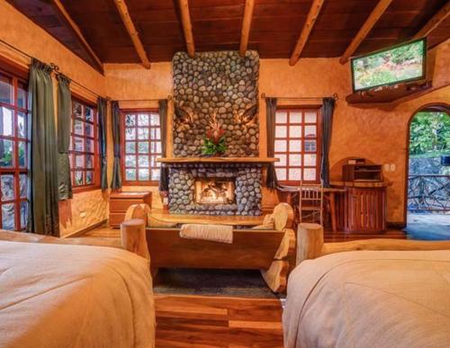 a living room with two beds and a fireplace at Peace Lodge in Vara Blanca