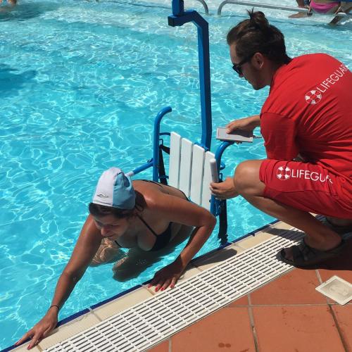 a woman in a swimming pool next to a man at San Francesco Camping Village in Desenzano del Garda