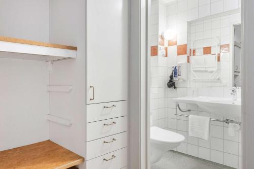 a white bathroom with a sink and a toilet at Best Western Solhem Hotel in Visby