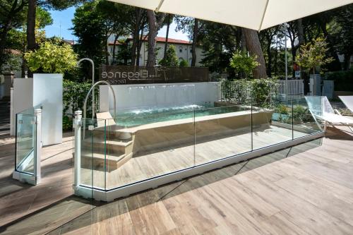 bañera de hidromasaje en un recinto de cristal en un patio en Elegance Riccione, en Riccione