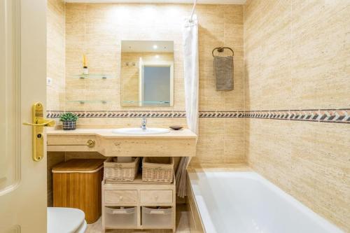ein Badezimmer mit einem Waschbecken, einer Badewanne und einem Spiegel in der Unterkunft OleHolidays Señorío Gonzaga junto a Puerto Banús in Marbella