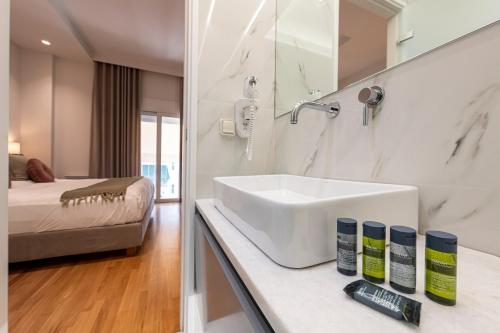 een witte badkamer met een wastafel en een bed bij Phaedrus Living City Center Luxury Flat Neos Kosmos in Athene
