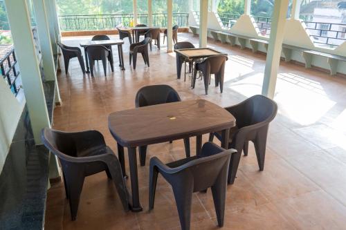 una fila de mesas y sillas en un restaurante en Anandvan Beach Resort, en Alibaug