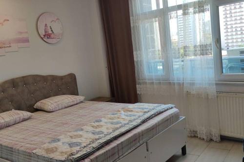 een slaapkamer met een bed met een deken en een raam bij Midtown Hotel Apartments 404 ( 2+1) in Istanbul