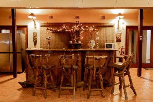 a kitchen with a bar with stools around it at Sunbird Lodge in Phalaborwa