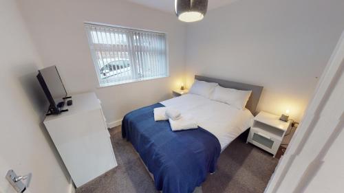 um pequeno quarto com uma cama e uma televisão em Apartment 332 em Hull