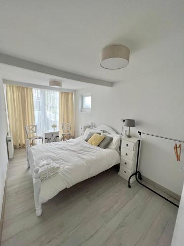 a white bedroom with a large bed and a desk at Newly renovated 1 bedroom flat with garden pergola in Ennis