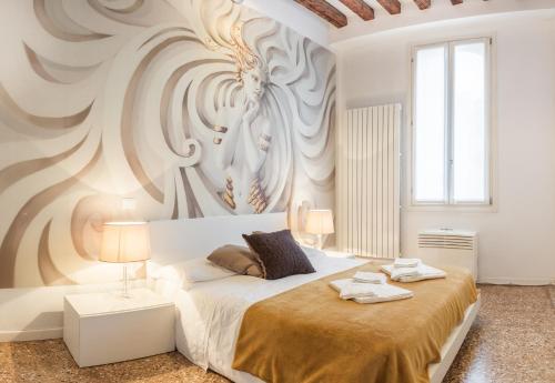 een slaapkamer met een bed met een schilderij aan de muur bij San Polo Design Apartments by Wonderful Italy in Venetië