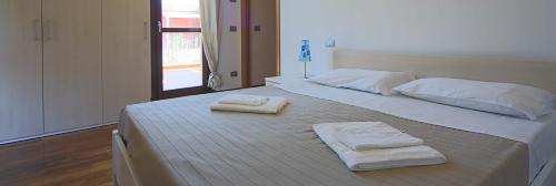 1 cama grande con 2 toallas encima en Adamo ed Eva Resort en Numana