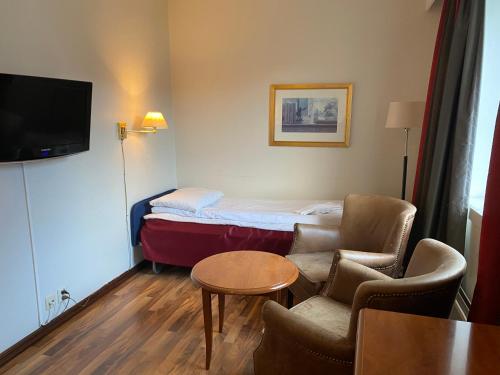a hotel room with a bed and two chairs and a table at Park Hotel Vossevangen in Vossevangen