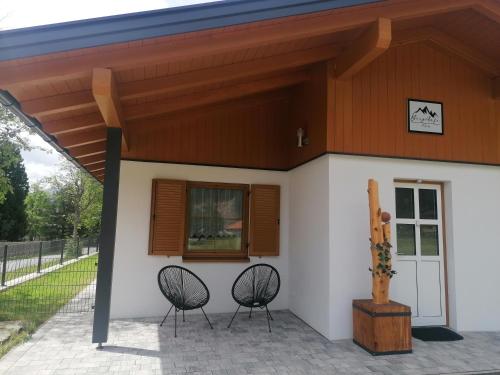a house with two chairs in front of it at BergAufe Chalets Mallnitz in Mallnitz