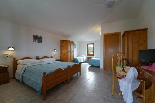 a bedroom with a bed and a flat screen tv at Villaggio Torre Ruffa Robinson in Capo Vaticano