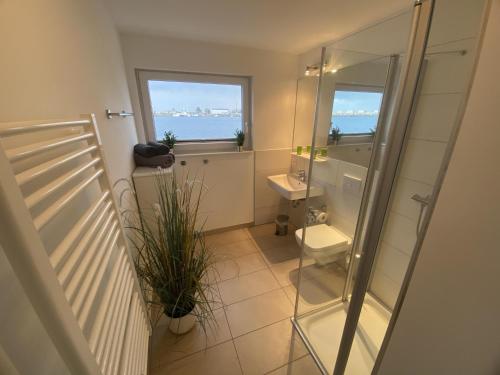 オルペニッツにあるHausboot ANTARES ONE by Seeblick Ferien OROのバスルーム(トイレ、洗面台付)、窓2つが備わります。
