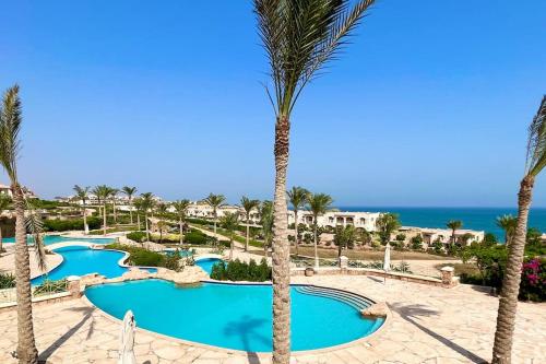 vista para as piscinas do resort com palmeiras em Amazing Beachfront townhouse chalet Ain Sokhna LaVista 1 em Ain Sokhna