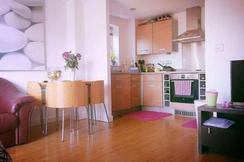 uma cozinha com uma mesa e uma cozinha com um fogão em Superhost 1 bedroom flat 15 mins to center,zone 2. em Londres