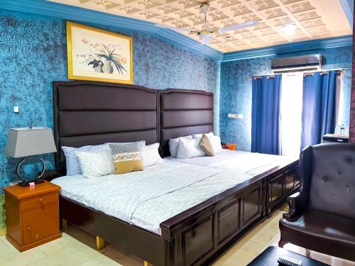 a bedroom with a large bed with blue walls at Golden Touch Executive Hotel in Tema