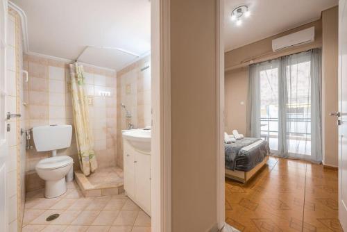 a bathroom with a bed and a toilet and a sink at Pegasus Apartment in Piraeus