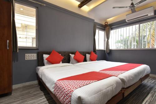 索拉普的住宿－Hotel Ashirwad, Solapur，一间卧室配有一张带红色枕头的大床
