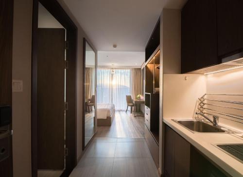 a kitchen with a sink and a living room at SeaHaven Panorama Nha Trang Superview Apartments in Nha Trang