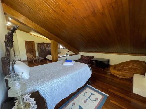 a bedroom with a bed and a wooden ceiling at Casa do Alto (top floor apartment) in Adaúfe
