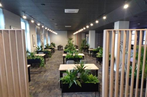 a dining room with tables and potted plants at Hotel IOR in Poznań